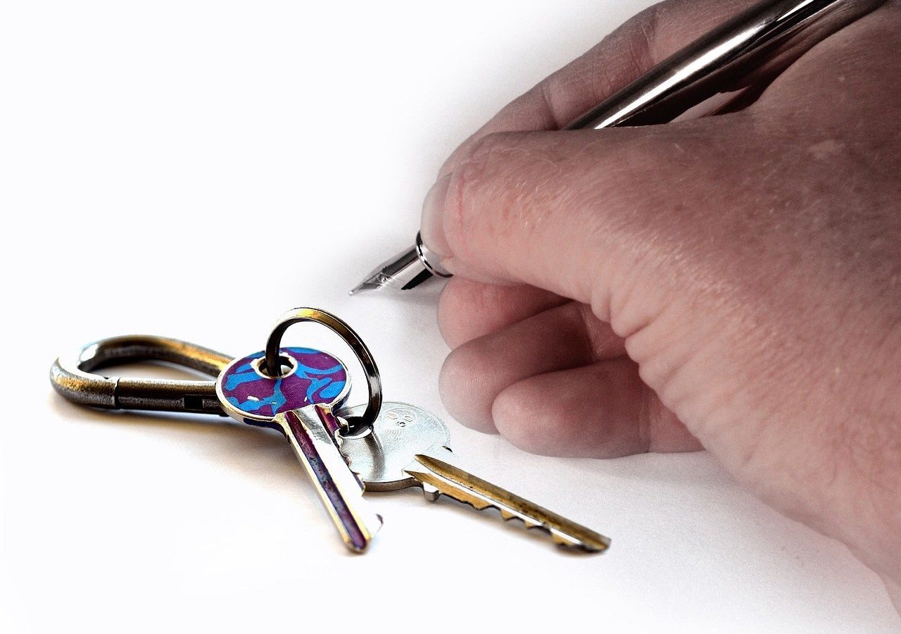 Main tenant des clés d'appartement près d'un contrat de bail signé