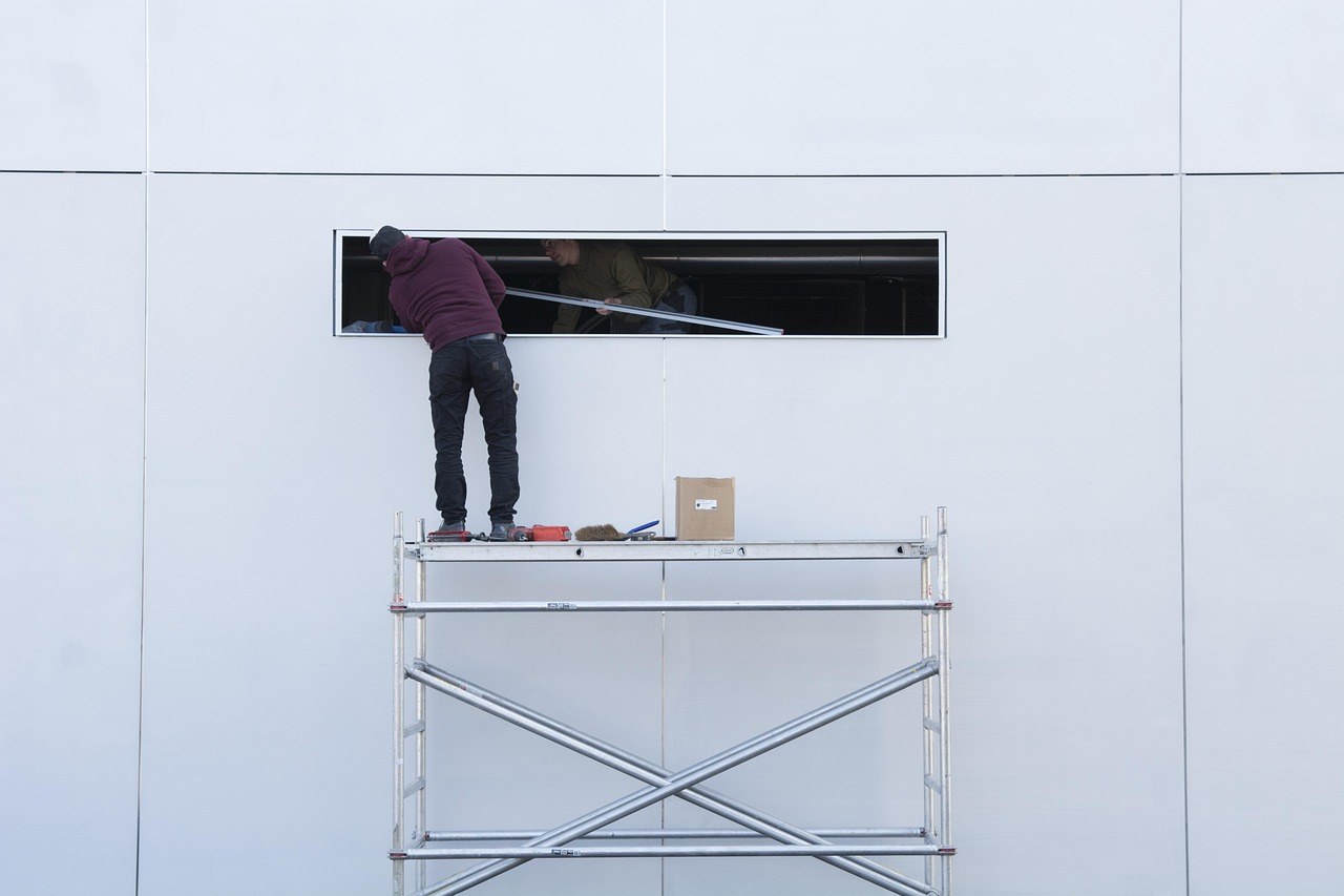 Ouvrier sur un échafaudage pour des travaux de façade d'immeuble