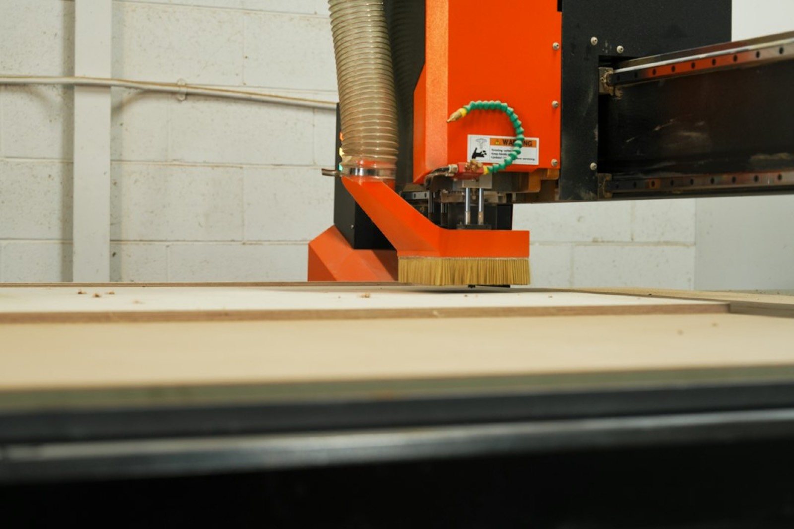 Atelier de gravure sur bois avec machine laser et pièces en cours de découpe